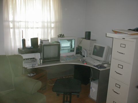 1999 Ford Crown Victoria - An office scene with multiple computer monitors, a filing cabinet, and a chair in front of a desk.
