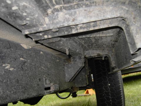 1977 Jeep Wagoneer - Undercarriage view of a vehicle, focusing on the frame and tire. Supermotors.net logo is present.