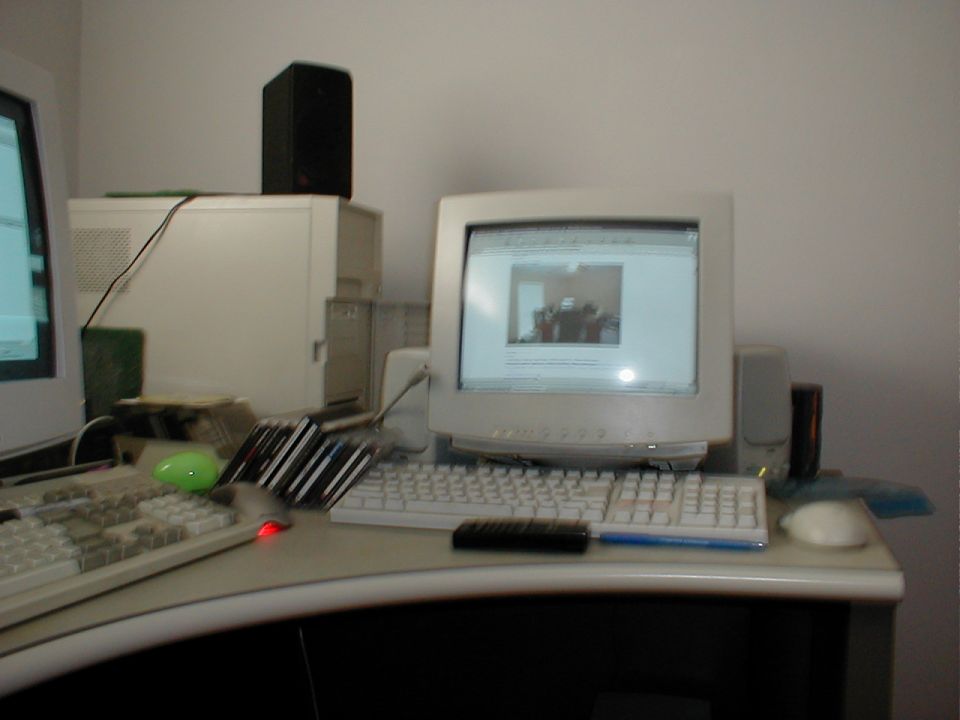 Desk with two computer monitors, keyboards, speakers, and a tower
