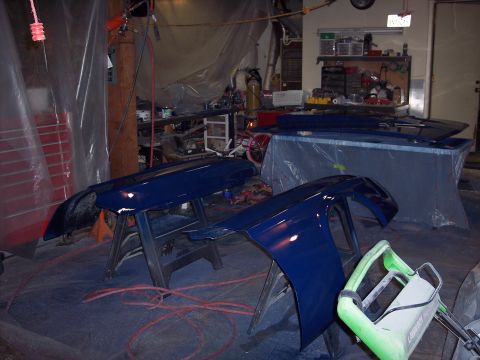 1971 Ford Mustang - Car fenders are being painted in a workshop environment.