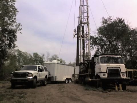 2000 Ford Excursion - A 2000 Ford Excursion is parked next to a large drilling rig and a white trailer.