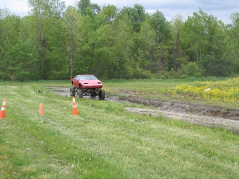 1978 Ford Bronco - A modified car navigates a muddy track during an off-road event.