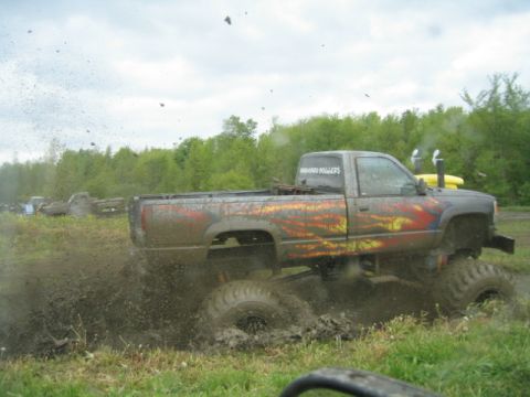 1978 Ford Bronco - Mud bogging event with a heavily modified pickup truck creating a large splash.