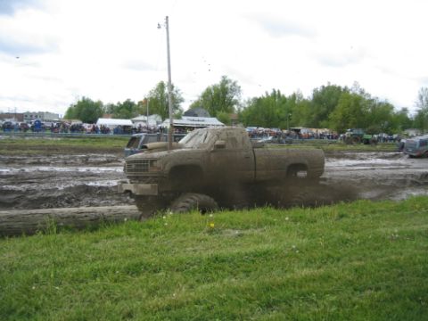 1978 Ford Bronco - A truck is deep in the mud during a competition with a crowd watching.