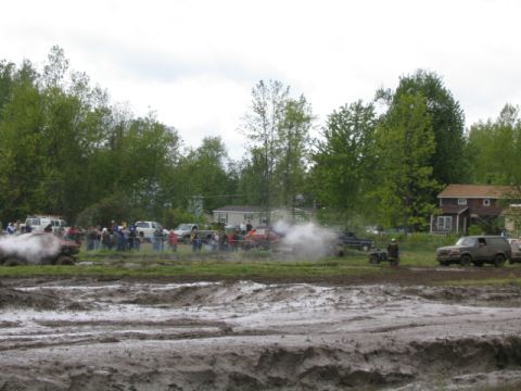 1978 Ford Bronco - Off-road vehicles participate in a mud bogging event with spectators gathered to watch the action.
