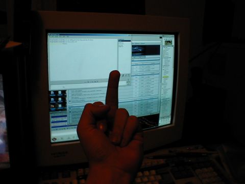 1999 Ford Crown Victoria - A hand is shown giving the middle finger in front of a computer monitor displaying a spreadsheet.