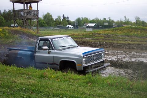 1978 Ford Bronco - A GMC pickup truck navigates a muddy obstacle course, with a banner on the windshield reading "BARNHARD BOLLERS".
