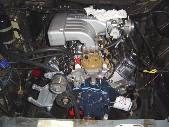 V8 engine bay with silver intake, tan distributor cap, blue block and white oil filter