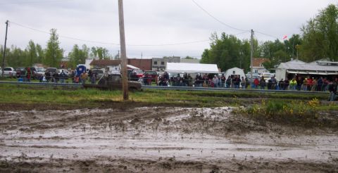 1978 Ford Bronco - A muddy track with a truck stuck, while a crowd watches the event.