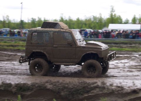 1978 Ford Bronco - This heavily muddied off-road vehicle navigates through a challenging mud pit during an event.