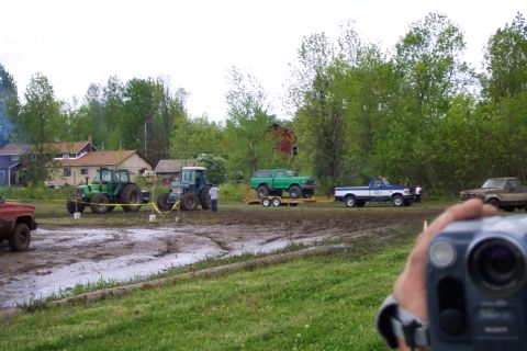 1978 Ford Bronco - A green 1978 Ford Bronco is transported on a trailer at an outdoor event with tractors and trucks present.