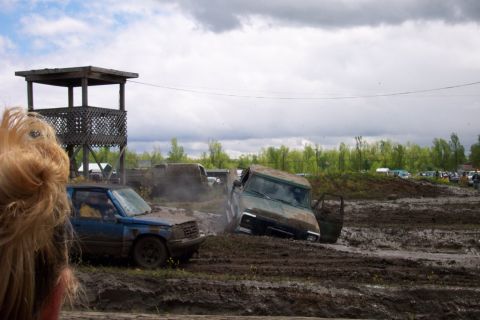 1978 Ford Bronco - Vehicles are stuck in a muddy field with a cloudy sky overhead.