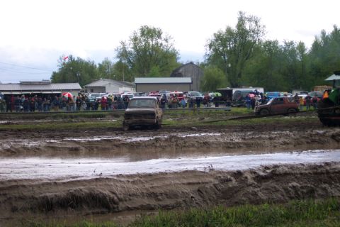 1978 Ford Bronco - A muddy pickup truck navigates a challenging course, with spectators watching from the sidelines.