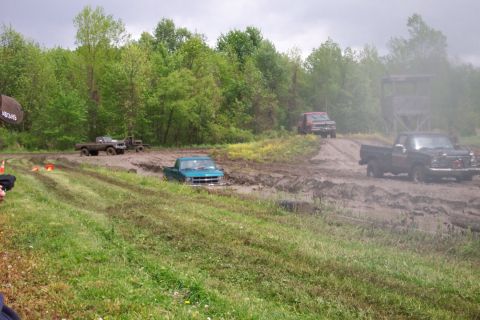 1978 Ford Bronco - Multiple trucks navigate a challenging muddy terrain, with some becoming stuck in the mire.