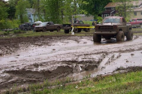 1978 Ford Bronco - Several trucks participate in a mud bogging event, navigating through challenging muddy terrain.