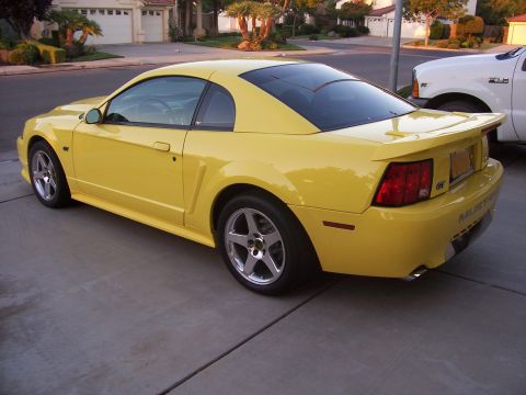 2002 Ford Mustang - Rear view of a yellow 2002 Ford Mustang GT with a spoiler and GT badging.