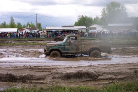 1978 Ford Bronco - Mud bogging event with a vintage pickup truck struggling through the mire.