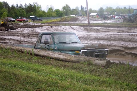 1978 Ford Bronco - A green 1979 Ford F-Series pickup truck is stuck in a mud pit during an off-road event.