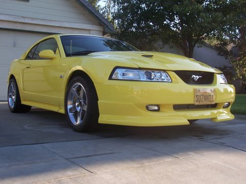 2002 Ford Mustang - Yellow 2002 Ford Mustang GT with custom license plate 'SUZNNQL'.