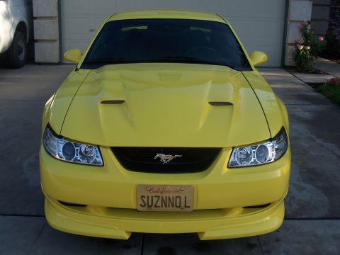 2002 Ford Mustang - Front view of a yellow 2002 Ford Mustang, showing its grille, headlights, and California license plate.