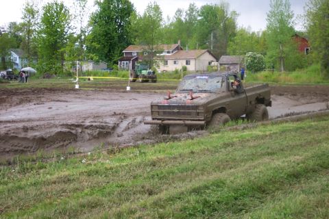 1978 Ford Bronco - A pickup truck is stuck in a mud pit during an off-road event.