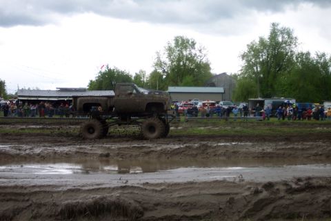 1978 Ford Bronco - A lifted pickup truck navigates a muddy track during a mud bogging event.