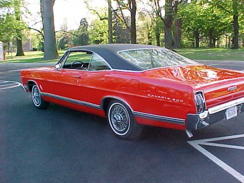 1967 Ford Galaxie - This red 1967 Ford Galaxie coupe features a black vinyl roof and is shown from the rear three-quarter angle.
