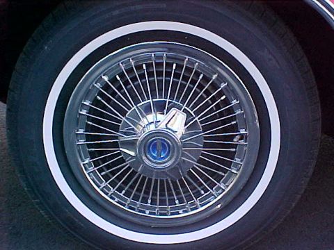 1967 Ford Galaxie - Wire wheel hubcap with a blue emblem is visible on a tire with a white stripe.