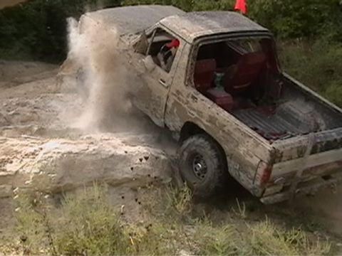 1988 Ford Bronco - Pickup truck struggling on a rocky off-road trail.