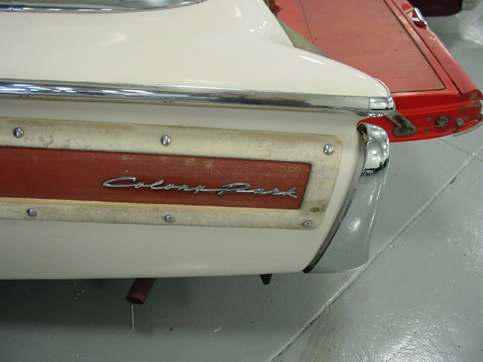 Rear quarter of white car with woodgrain panel and 'Colony Park' script badge in garage.