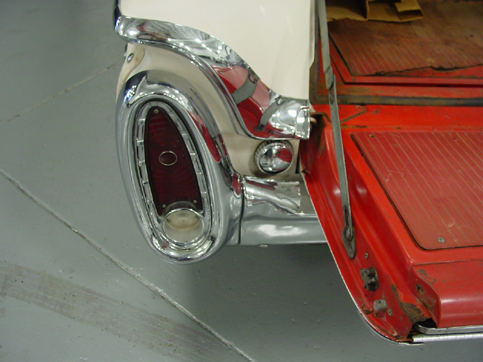 Rear corner of white and red classic wagon with chrome oval taillight