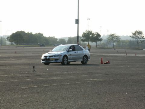 2001 Mercury Grand Marquis - A silver sedan with a prominent rear spoiler navigates a course marked by traffic cones.