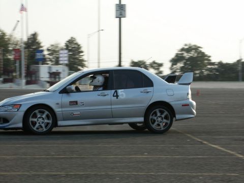 2001 Mercury Grand Marquis - A silver sedan with racing decals and a spoiler is captured in motion on a track.