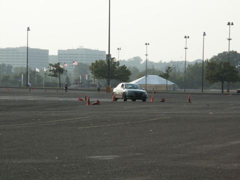2001 Mercury Grand Marquis - A silver sedan navigates a cone course in an open lot with buildings in the background.