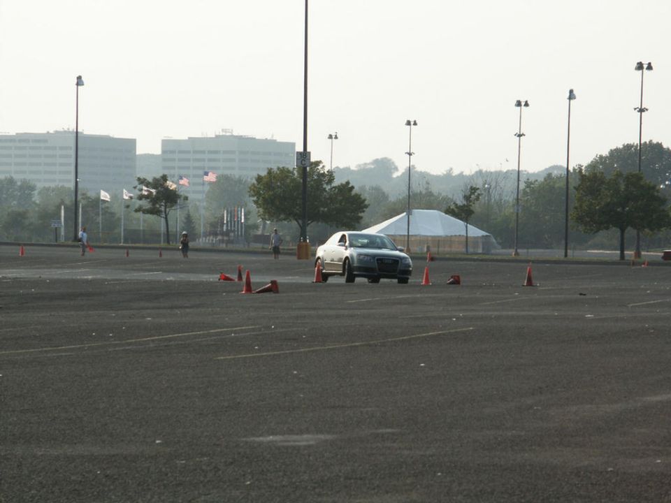 Silver sedan driving through a cone course in a parking lot