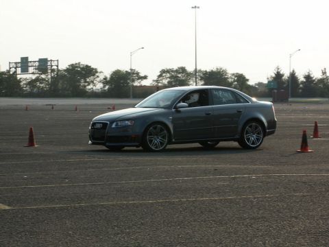 2001 Mercury Grand Marquis - A dark gray sedan navigates a course marked by orange cones on a paved track under an overcast sky.