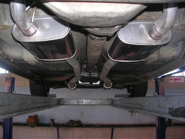 Underside view of a car showing dual exhaust mufflers and pipes