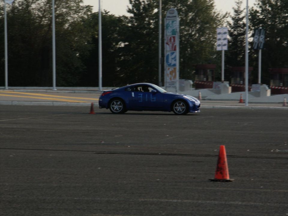 Blue sports car with number 316 on door driving on asphalt course