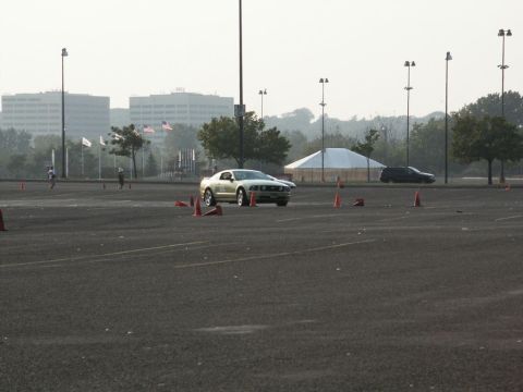 2001 Mercury Grand Marquis - A gold Ford Mustang navigates an autocross course with orange cones marking the path.