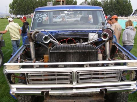 1994 Ford F-150 - Head-on view of a blue 1970s Ford pickup pulling truck with the hood removed, showing twin turbochargers with cone air filters mounted on l…