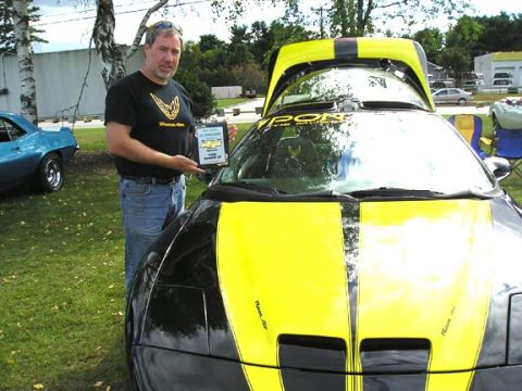 1994 Pontiac Trans Am - A man proudly displays his award next to his customized 1994 Pontiac Trans Am.