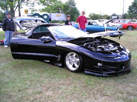 1994 Pontiac Trans Am - A black 1994 Pontiac Trans Am is displayed with its hood and driver's door open, revealing the engine bay.