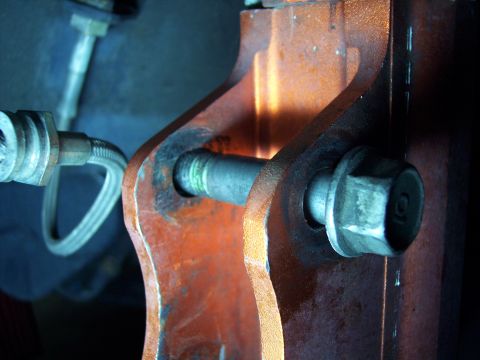 1995 Ford Probe - A close-up view of a vehicle's suspension system shows a bolted connection and a brake line.