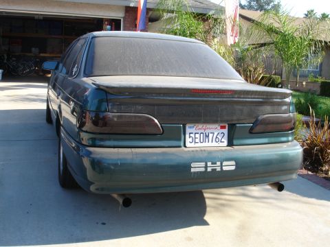 1993 Ford Taurus - The rear of a 1993 Ford Taurus SHO is shown, a California license plate and dual exhaust pipes.
