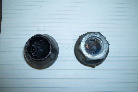 1983 Ford Bronco - Two wheel lug nuts are shown on a piece of lined paper, one appears to be black and the other silver.