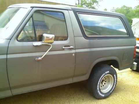 1985 Ford Bronco - The side profile of a gray Ford Bronco shows its distinctive body style and aftermarket wheels.