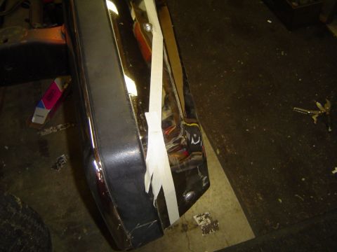 1989 Ford Bronco - Close-up of chrome bumper trim, partially covered with white tape.