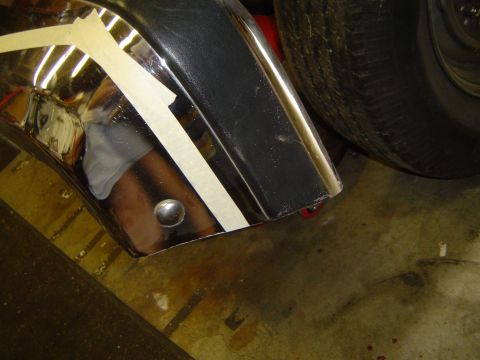 1989 Ford Bronco - Close-up of chrome bumper trim with masking tape, likely for a repair or modification.