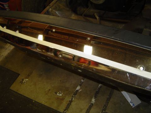 1989 Ford Bronco - Close-up view of chrome bumper trim with a white accent strip and visible mounting hardware.