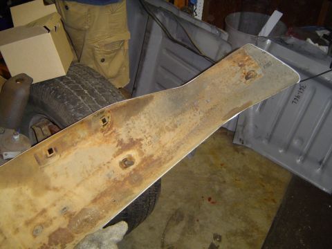 1989 Ford Bronco - Close-up of a rusty metal trim piece, possibly a bumper component, with a visible part number.